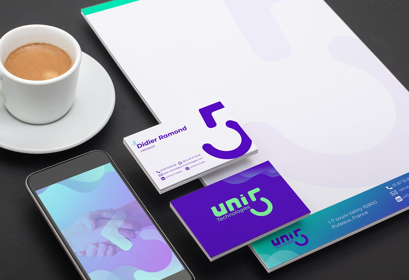 Papelaria e cartões de visita da Uni5 Technologies, com uma xícara de café